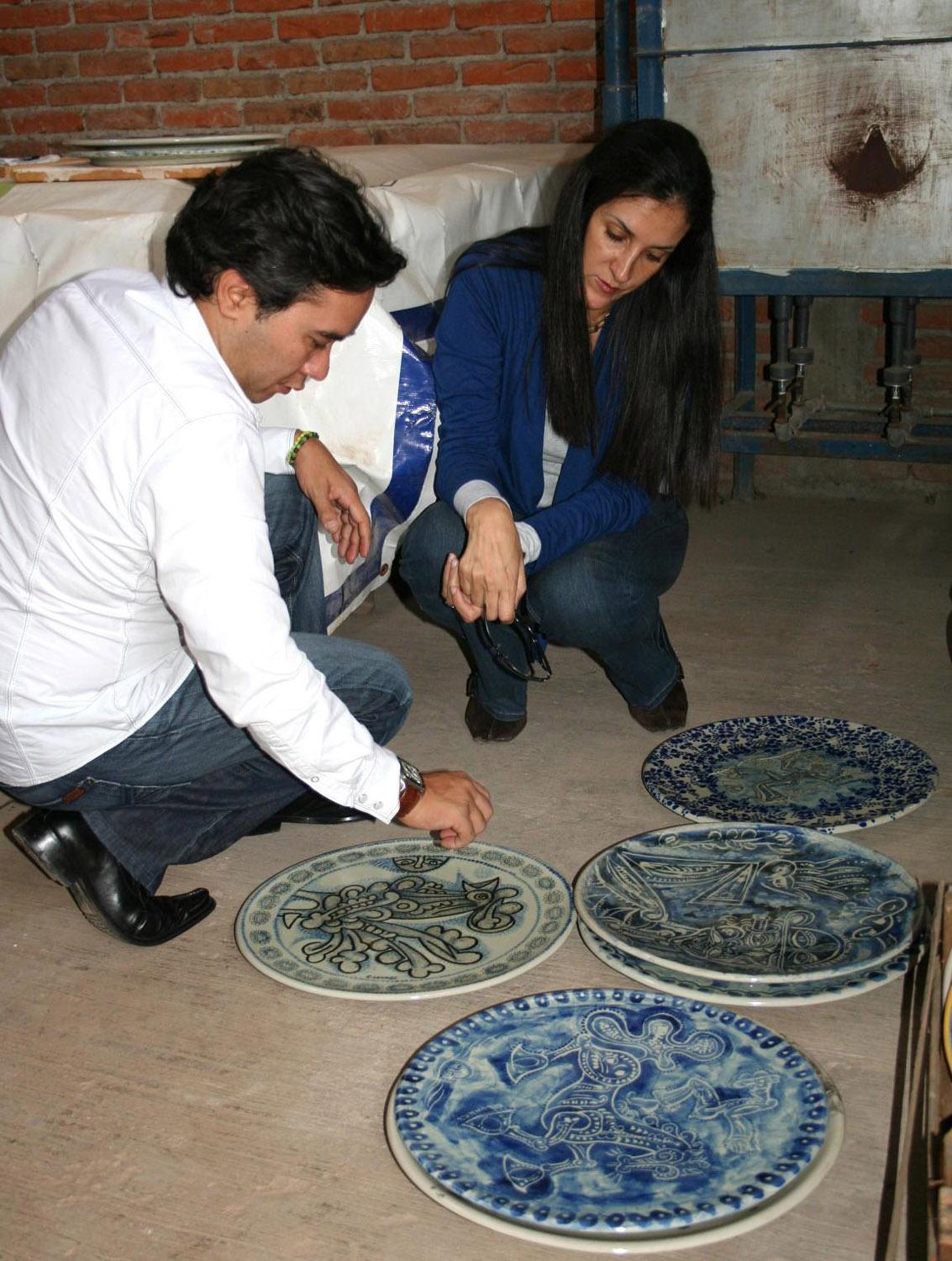 Carlos and Claudia Luna examining ceramics before an exhibition, Puebla, Mexico, 2010